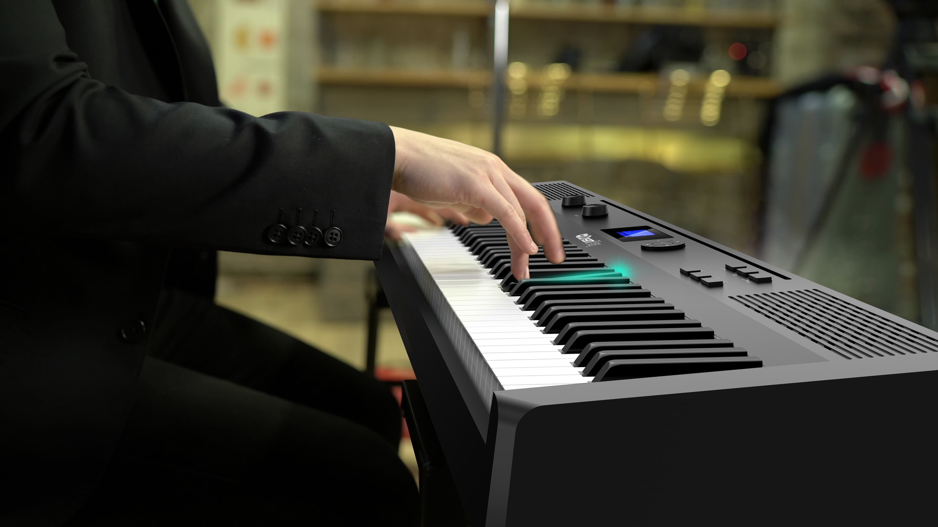 Hand in black suit playing piano keys